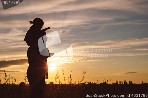 Image of Father and son playing in the park at the sunset time.