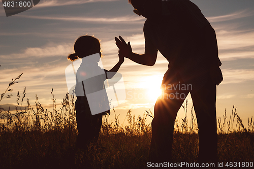 Image of Father and son playing in the park at the sunset time.