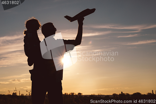 Image of Father and son playing in the park at the sunset time.