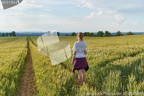 Image of Green field and a girl standing on it