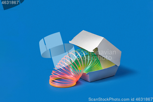 Image of Flexible rainbow spring in a silver food container.