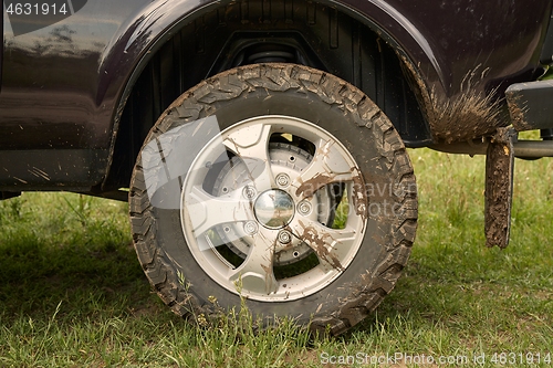 Image of Rear wheel of a 4x4 vehicle dirty with mud