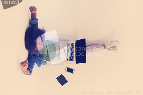 Image of african american woman sitting on floor with laptop top view