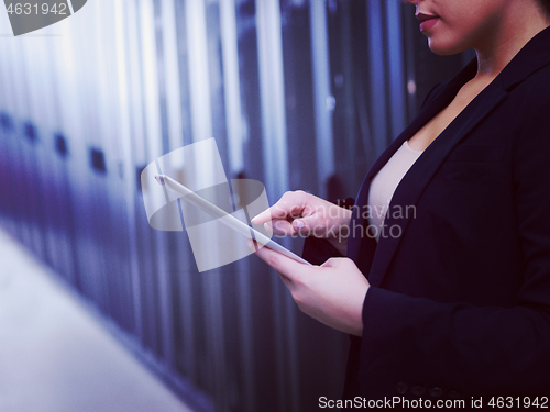 Image of Female engineer working on a tablet computer in server room