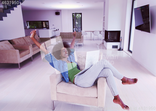 Image of African American women at home in the chair using a laptop