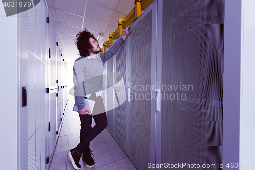 Image of IT engineer working on a tablet computer in server room