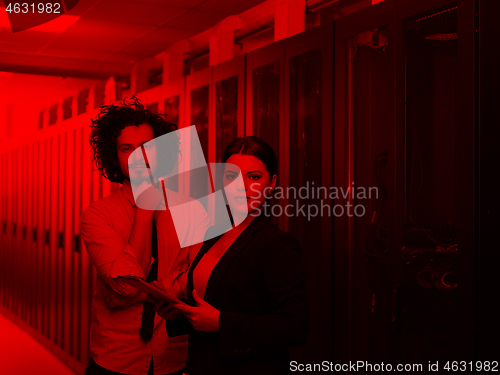 Image of engineer showing working data center server room to female chief