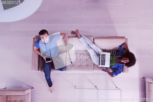 Image of young multiethnic couple relaxes in the living room top view