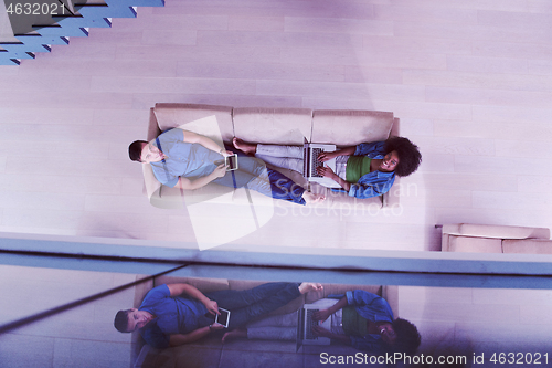 Image of young multiethnic couple relaxes in the living room top view