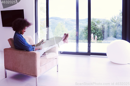 Image of african american woman at home with digital tablet