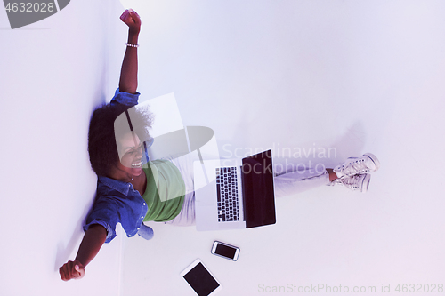 Image of african american woman sitting on floor with laptop top view