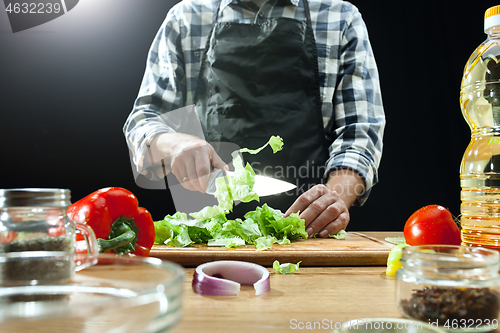 Image of Preparing salad. Female chef cutting fresh vegetables. Cooking process. Selective focus