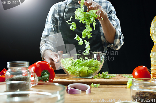 Image of Preparing salad. Female chef cutting fresh vegetables. Cooking process. Selective focus