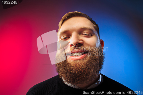 Image of The happy man standing and smiling against pink background.