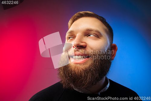 Image of The happy man standing and smiling against pink background.