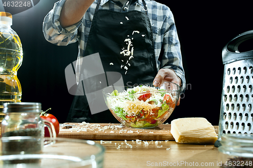 Image of Preparing salad. Female chef cutting fresh vegetables. Cooking process. Selective focus