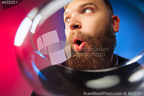 Image of The surprised young man posing with glass of wine.