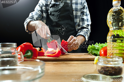 Image of Preparing salad. Female chef cutting fresh vegetables. Cooking process. Selective focus