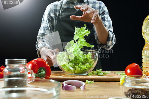 Image of Preparing salad. Female chef cutting fresh vegetables. Cooking process. Selective focus