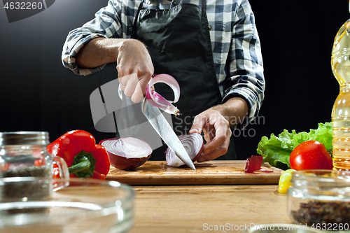 Image of Preparing salad. Female chef cutting fresh vegetables. Cooking process. Selective focus