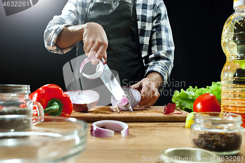 Image of Preparing salad. Female chef cutting fresh vegetables. Cooking process. Selective focus