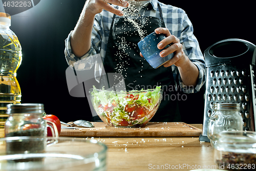 Image of Preparing salad. Female chef cutting fresh vegetables. Cooking process. Selective focus