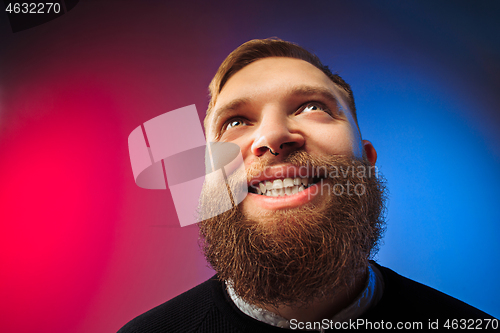 Image of The happy man standing and smiling against pink background.