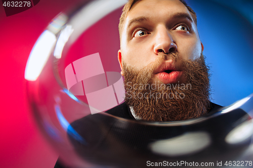 Image of The surprised young man posing with glass of wine.