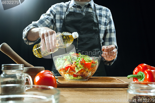 Image of Preparing salad. Female chef cutting fresh vegetables. Cooking process. Selective focus