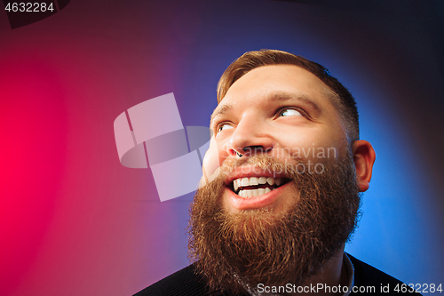 Image of The happy man standing and smiling against pink background.