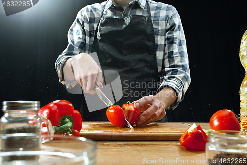 Image of Preparing salad. Female chef cutting fresh vegetables. Cooking process. Selective focus