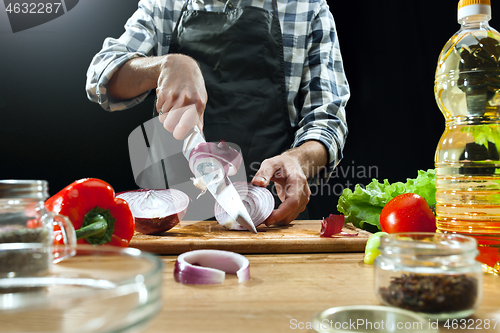 Image of Preparing salad. Female chef cutting fresh vegetables. Cooking process. Selective focus