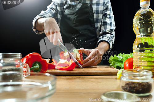 Image of Preparing salad. Female chef cutting fresh vegetables. Cooking process. Selective focus