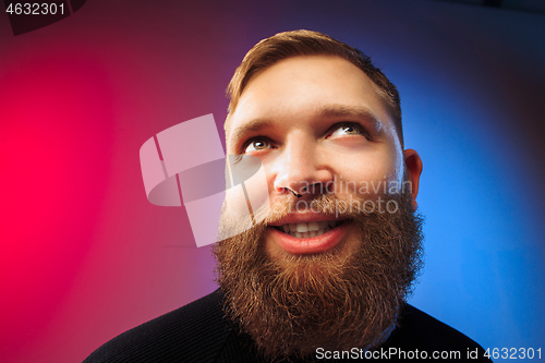 Image of The happy man standing and smiling against pink background.