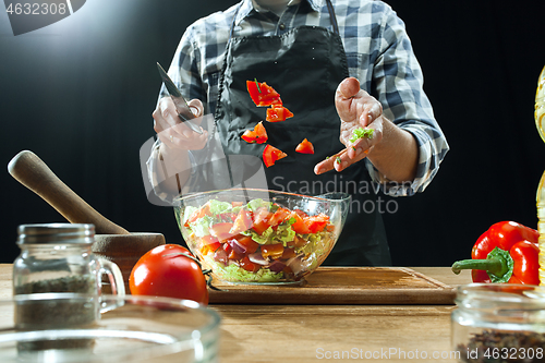 Image of Preparing salad. Female chef cutting fresh vegetables. Cooking process. Selective focus