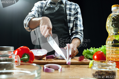 Image of Preparing salad. Female chef cutting fresh vegetables. Cooking process. Selective focus