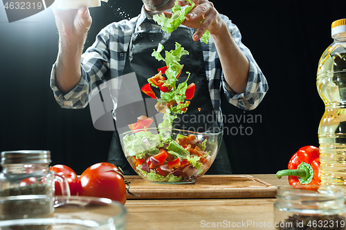 Image of Preparing salad. Female chef cutting fresh vegetables. Cooking process. Selective focus