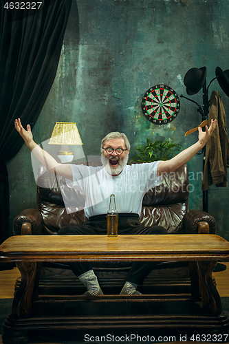Image of Winner. Overwhelmed cheerful man moving hands while celebrating the victory