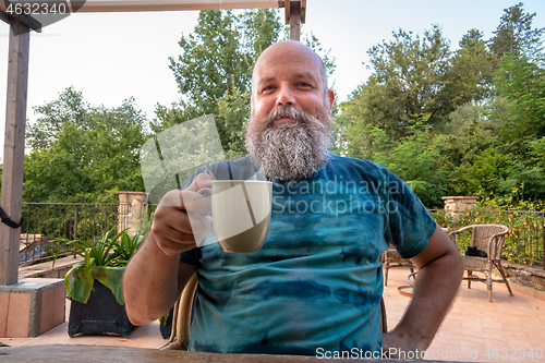 Image of bearded man hands on coffee mug