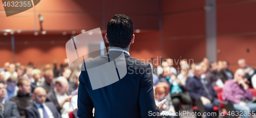 Image of Public speaker giving talk at business event.