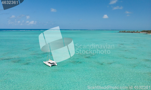 Image of Catamaran sailing boat in turquoise sea lagoon on tropial Mauritius island. Aerial, drone view.