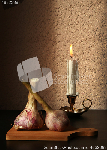 Image of Two garlic bulbs and candle