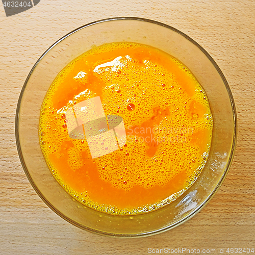 Image of Blending mix of hen eggs in transparent bowl on the kitchen tabl