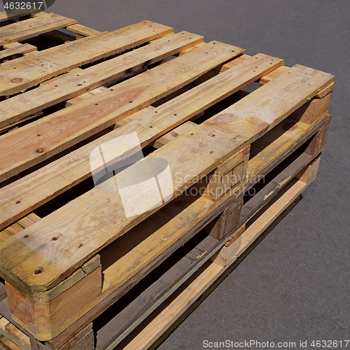 Image of Used wooden pallets lying on the asphalt pavement