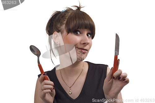 Image of The mad housewife with knife and spoon. funny picture