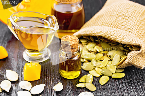 Image of Oil pumpkin in vial and sauceboat on board