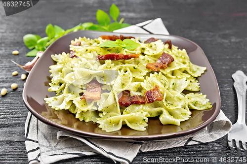 Image of Farfalle with pesto and bacon on wooden board