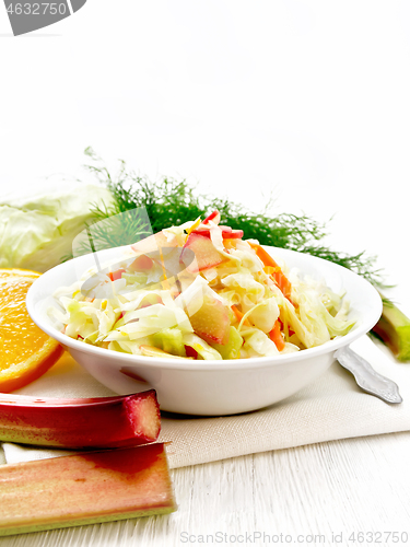 Image of Salad of cabbage and rhubarb in plate on wooden board