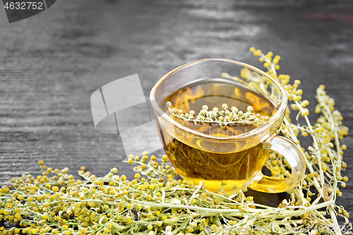 Image of Tea of gray wormwood in glass cup on board