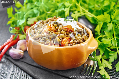 Image of Lentils with eggplant and tomatoes in bowl on board
